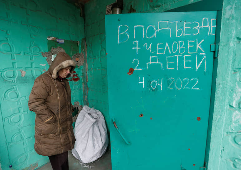 Местный житель у двери многоквартирного дома в Мариуполе